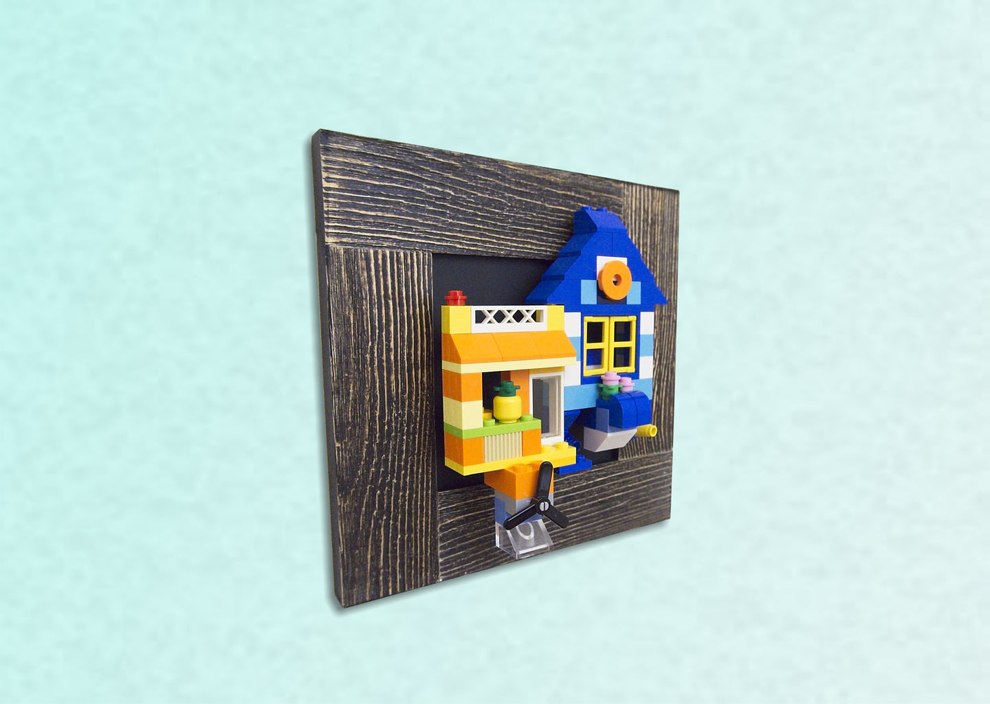 A blue and yellow flying home made from LEGO ® blocks is displayed on the wall using MBRIKS magnetic construction blocks.